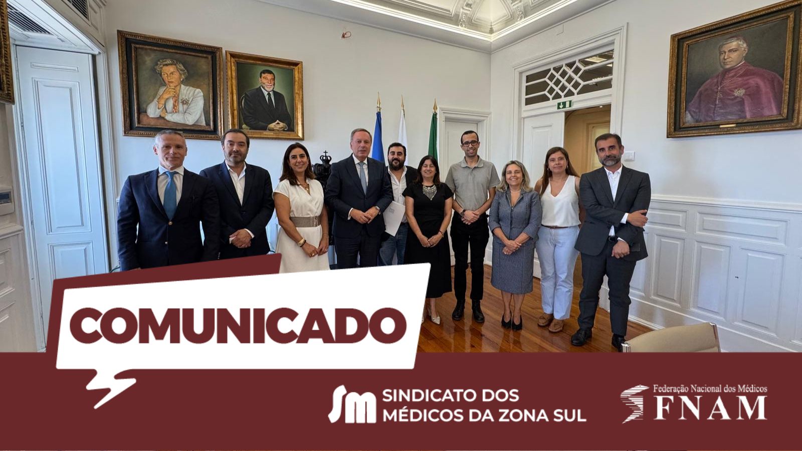 Imagem informativa com uma fotografia de grupo no centro de um salão nobre com chão de madeira e paredes brancas com boiserie. Dez pessoas (seis homens de fato e quatro mulheres em vestidos e trajes formais) estão de pé em duas filas ligeiramente desalinhadas. Na parede de fundo, veem-se três grandes retratos a óleo em molduras douradas e, ao centro, bandeiras de Portugal, da União Europeia e uma terceira branca. Na metade inferior, uma sobreposição gráfica inclui a palavra "COMUNICADO" em letras brancas num balão de fala sobre um fundo bordeaux, que contém também o logótipo SM e o nome "SINDICATO DOS MÉDICOS DA ZONA SUL" ao centro, e o logótipo "FNAM - Federação Nacional dos Médicos" à direita. Da direita para a esquerda, depois das primeiras duas pessoas, estão Ana Cristina Albuquerque (vestido azul/cinzento padronizado) e André Arraia Gomes (pólo cinzento).